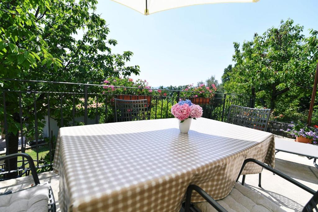 a white table with a vase of flowers on it at Holiday home in Moscenicka Draga 43083 in Kraj