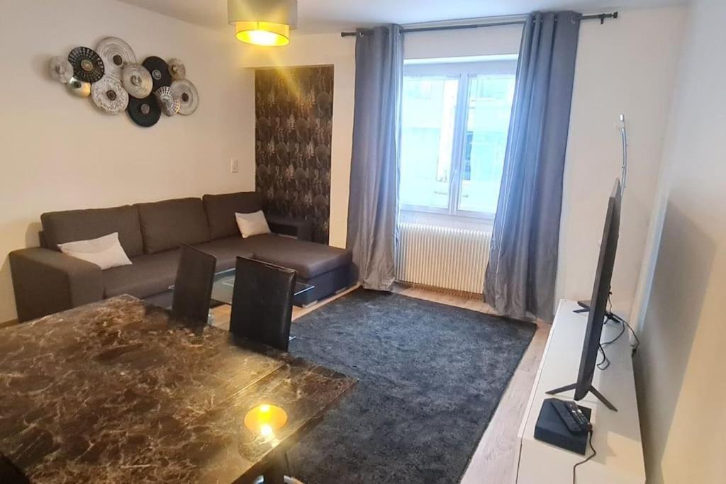 un salon avec un canapé et une télévision dans l'établissement Charmante Maison avec extérieur - Astérix & CDG, à La Chapelle-en-Serval