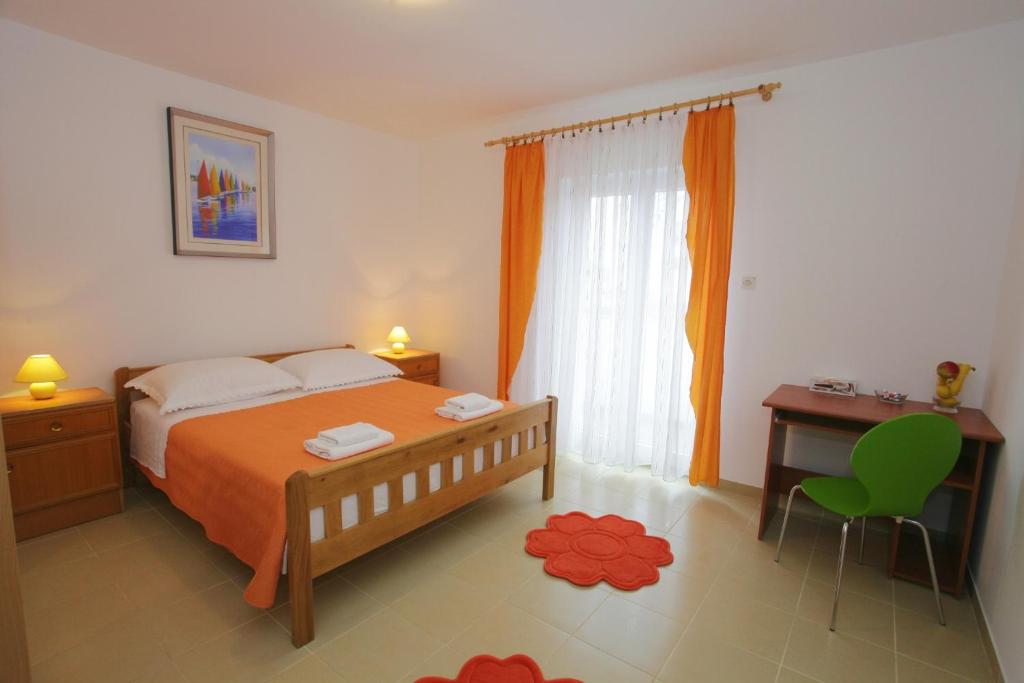 um quarto com uma cama, uma secretária e uma janela em Guest House Renata em Zadar