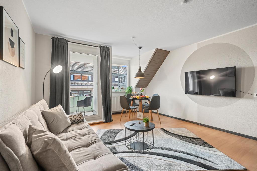 un soggiorno con un divano e un tavolo di BLICKFANG - zentrale Ferienwohnung im Herzen von Friedrichshafen a Friedrichshafen