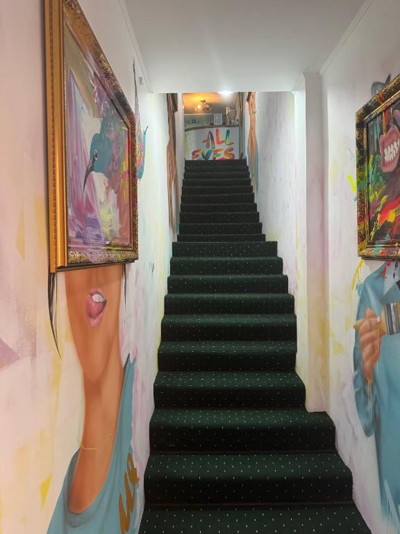 una scala in una stanza con un dipinto sul muro di All Eyes Hostel a Kam"janec'-Podil's'kyj