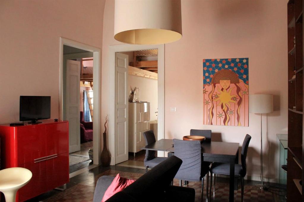 een woonkamer met een tafel en een schilderij aan de muur bij Casa Carolina in Giarre