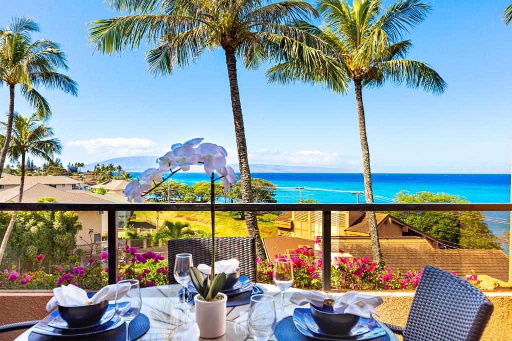 a table with a view of the ocean and palm trees at Kahana Villas - F508 - in Kahana