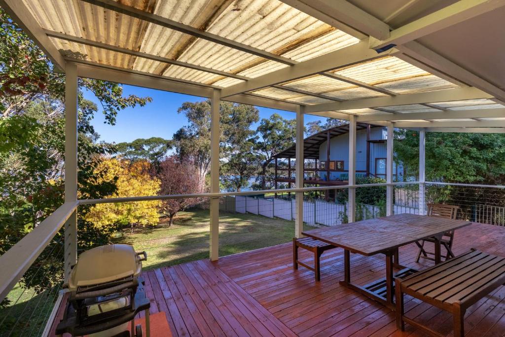 a patio with a table and chairs on a deck at 29 Flower Cct, Akolele in Central Tilba