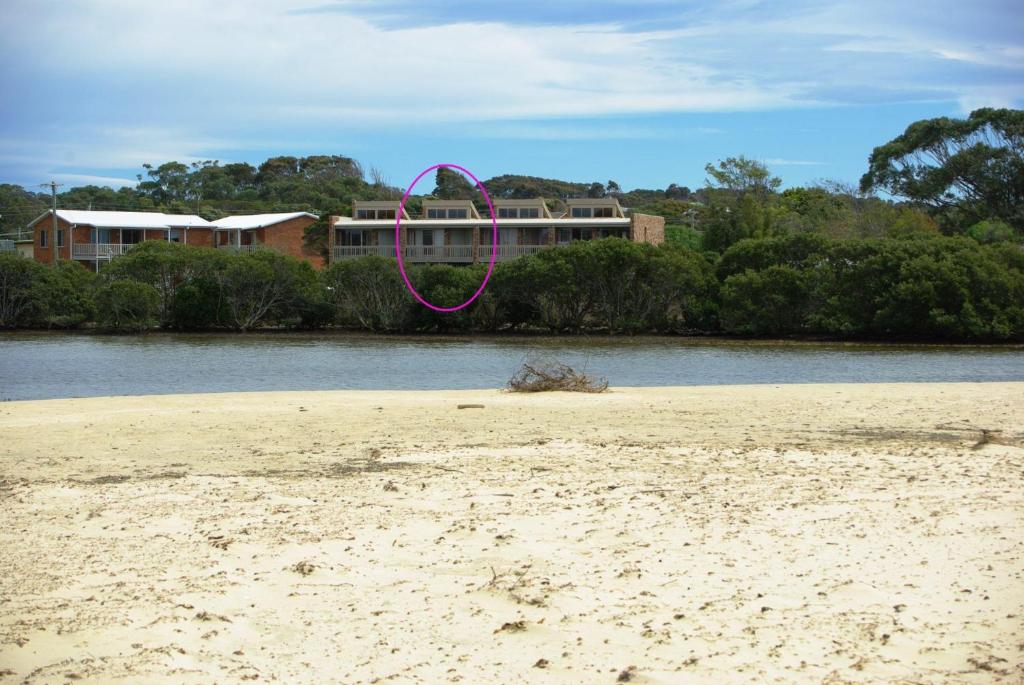 バーマグイにある3-6 Marina Townhouseの建物の隣に紫色のリボンが飾られたビーチ