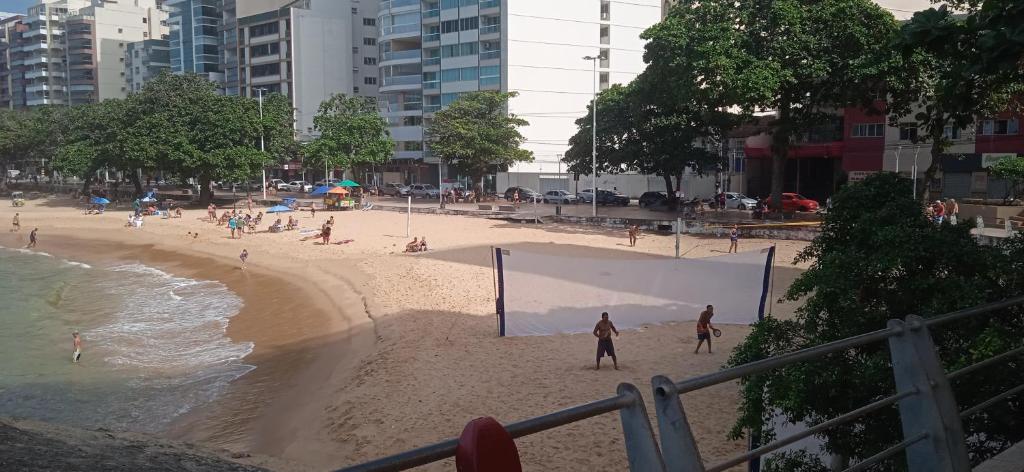 a beach with people playing volleyball on the sand at Próximo a praia das castanheiras, internet, cooler, cadeiras de praia,roupas de cama e banho in Guarapari