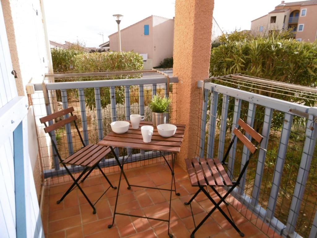 d'une petite table sur un balcon avec deux chaises. dans l'établissement Saint-Pierre-La-Mer : Appartement T2 avec WIFI, Parking privatif, Proche plage, 4 personnes - FR-1-795-1, à Fleury