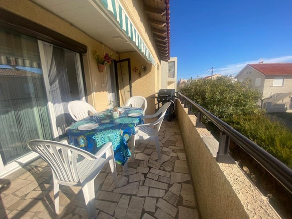 une table et des chaises sur le balcon d'une maison dans l'établissement Spacieux T3 climatisé proche plage, balcon, parking privatif - FR-1-795-19, à Narbonne