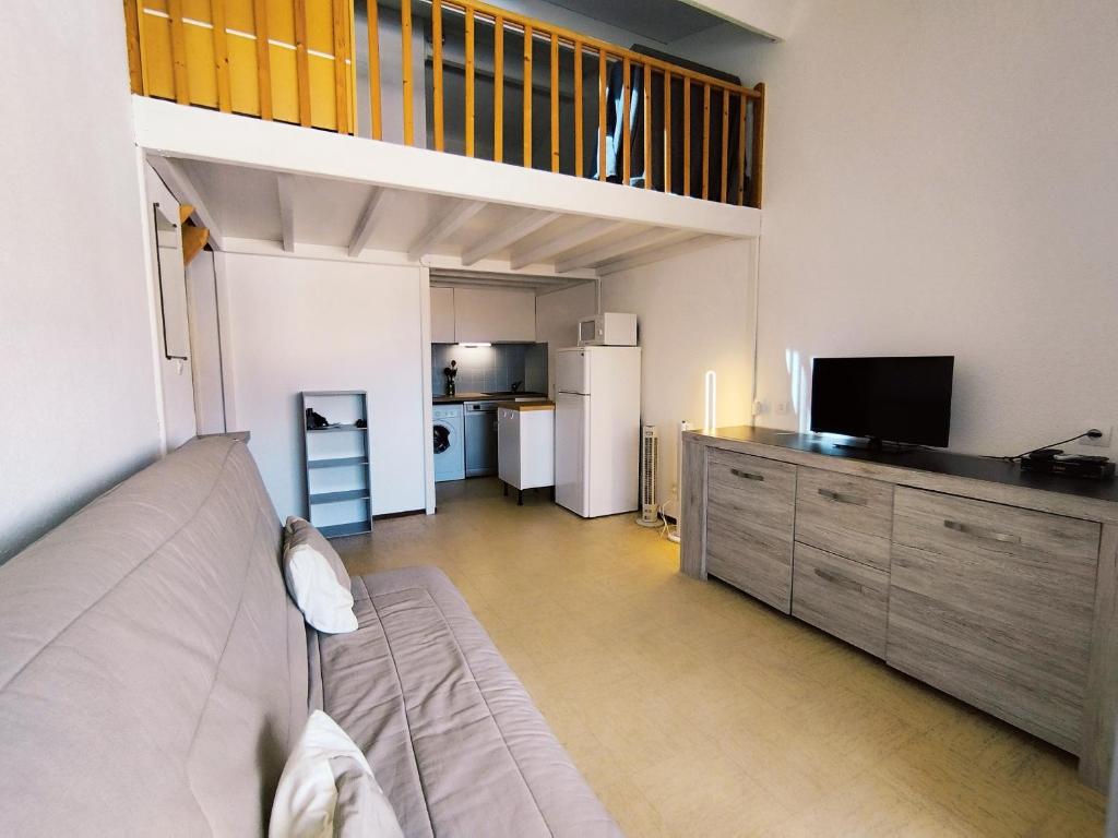 un salon avec un canapé et une cuisine dans l'établissement Appartement T2 Mezzanine à Narbonne-Plage, 30m², 5 pers, Proche Centre et Plage - FR-1-795-25, à Narbonne
