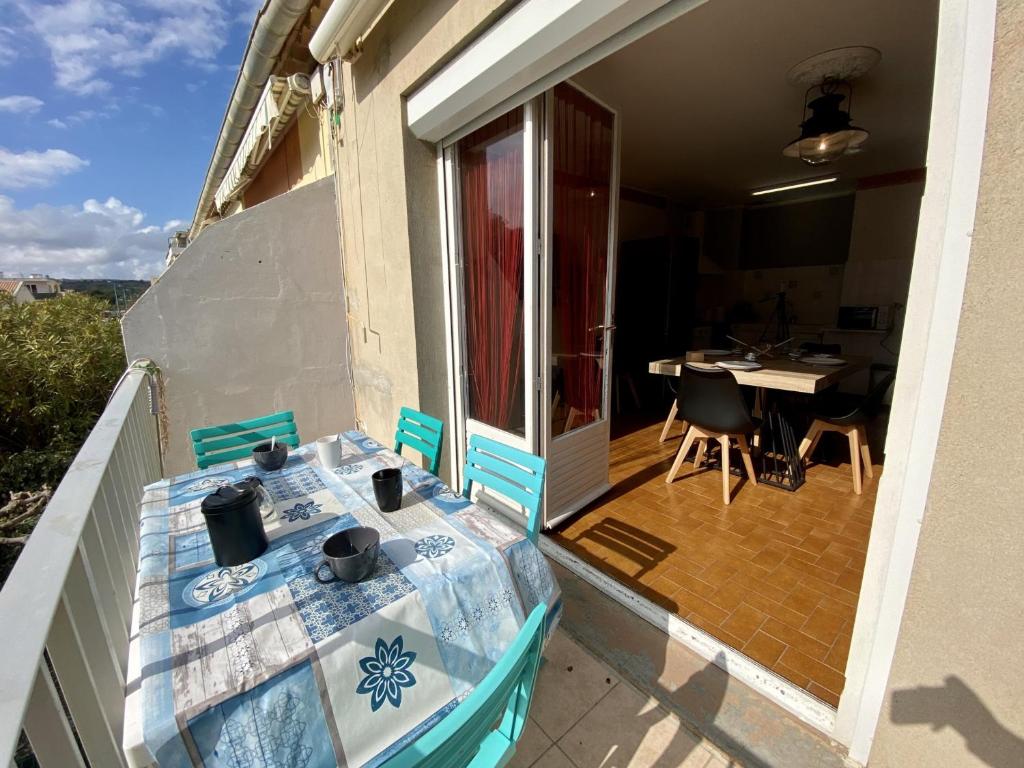 une table sur le balcon d'une maison avec une table et des chaises dans l'établissement Appartement T3 avec Clim et WIFI à 100m de la Plage - Parking Inclus - 6 Pers. - FR-1-795-34, à Narbonne