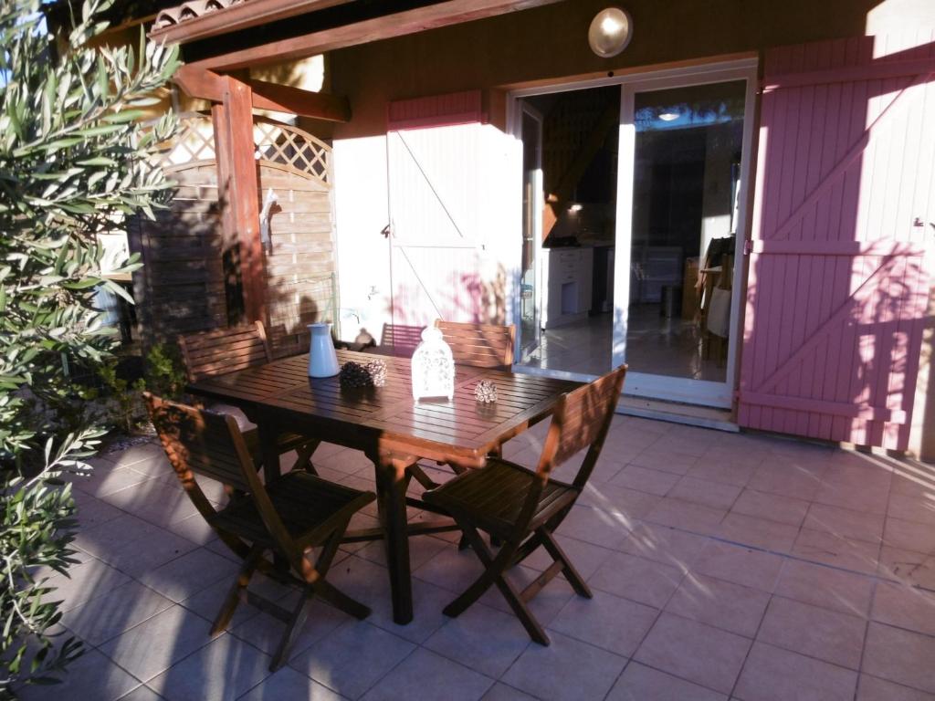une table et des chaises en bois sur une terrasse dans l'établissement Villa 7 pers, Narbonne Plage à 400m, 3 ch, terrasses, parking, proche commerces et loisirs - FR-1-795-44, à Narbonne