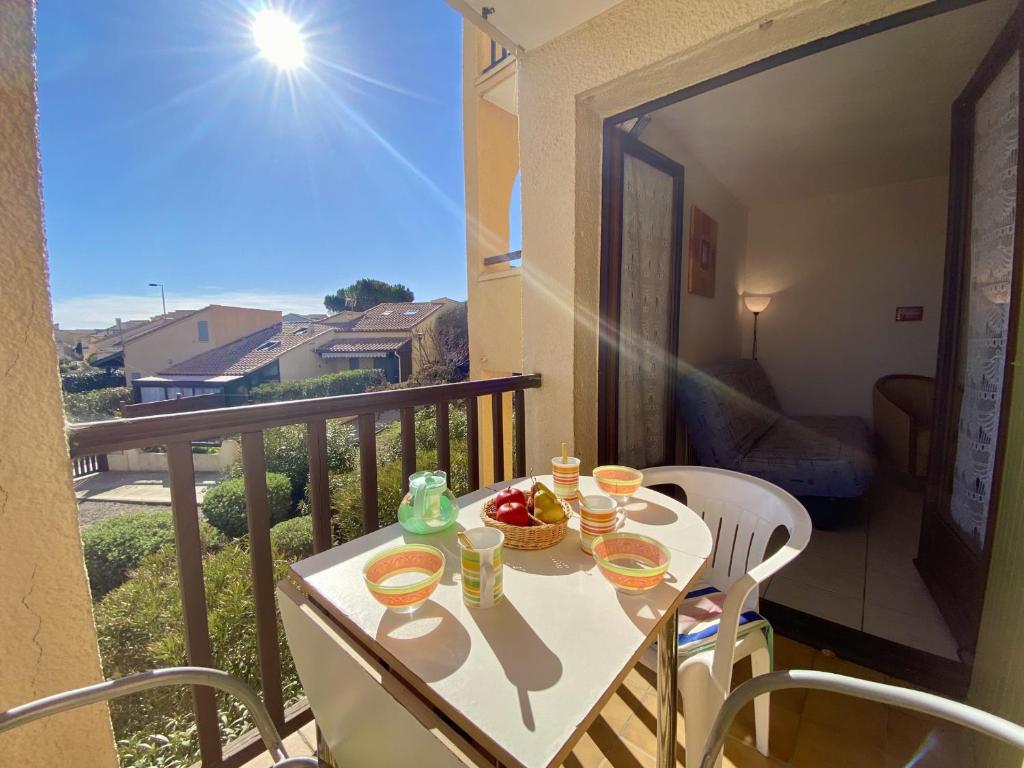 - un balcon avec une table et de la nourriture dans l'établissement T2 Confortable à Saint-Pierre-La-Mer - 4 Pers, Proche Plage, Tout Équipé, Balcon, Animations à Proximité - FR-1-795-47, à Fleury