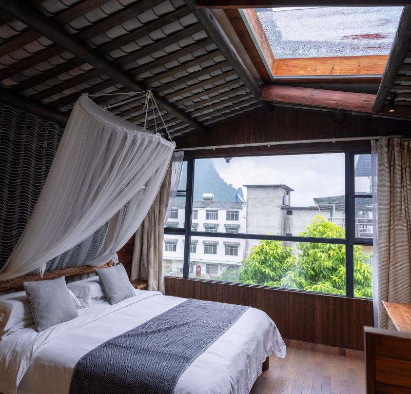 Postel nebo postele na pokoji v ubytování Yangshuo Shui Mo Ju courtyard