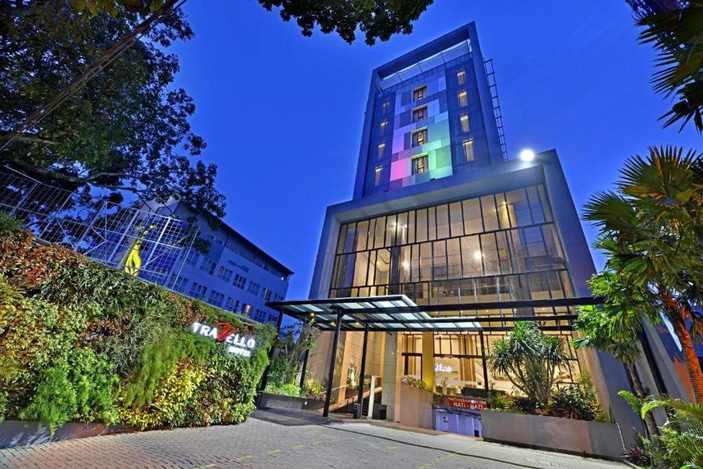 a tall building with a canopy in front of it at Travello Hotel Bandung in Bandung