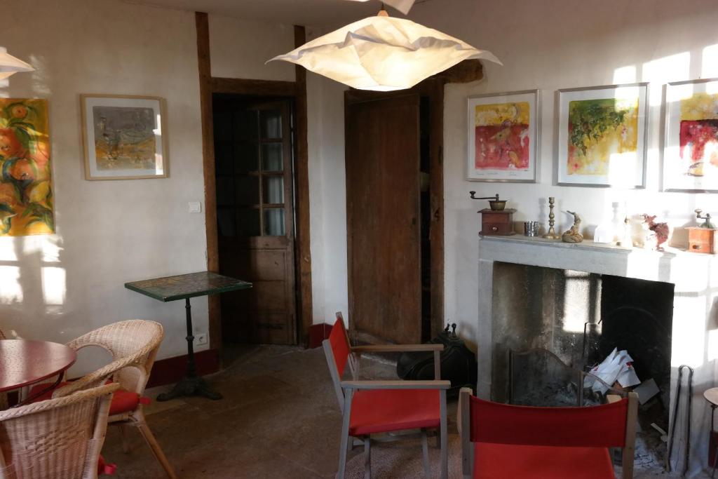 sala de estar con chimenea, mesa y sillas en le Petit Paris, en Flagey-Échézeaux