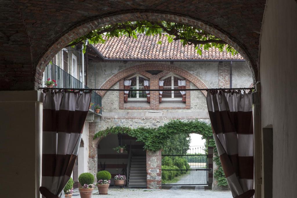 皮內羅洛的住宿－Agriturismo Il Torrione，通往植物建筑的拱门
