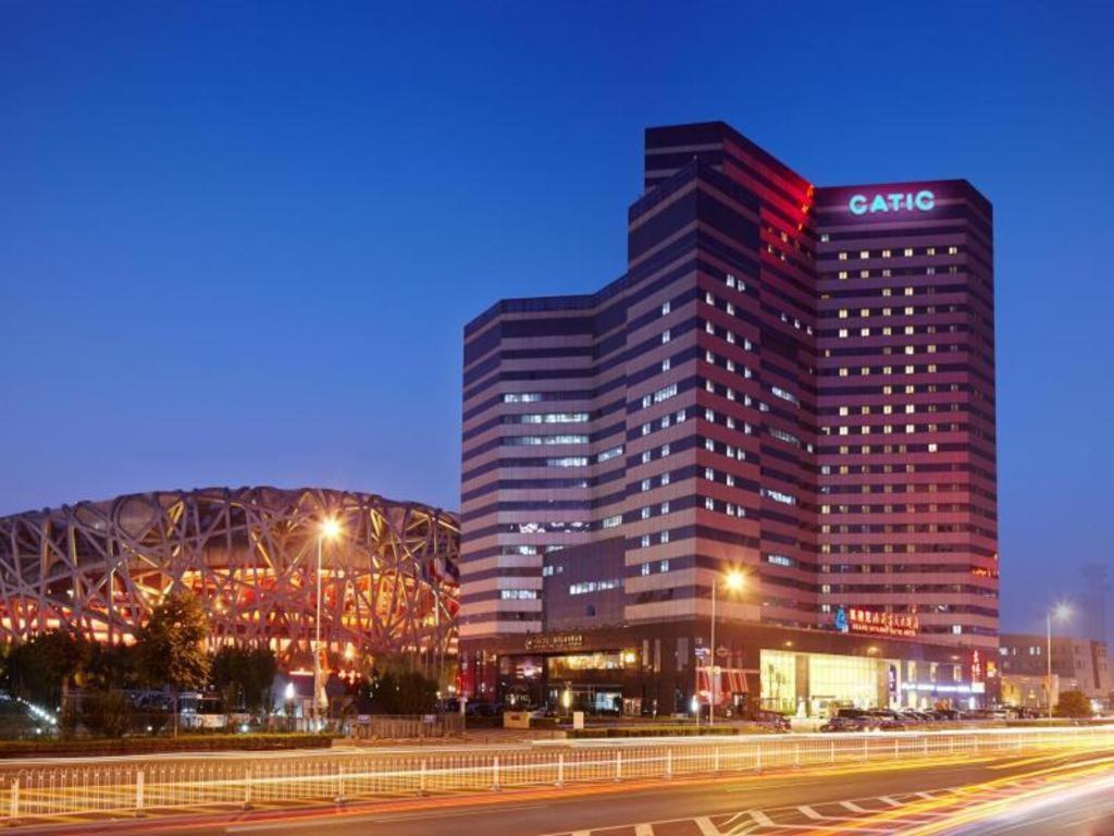 a large building with a sign on it at night at Grand Skylight Catic Hotel in Beijing