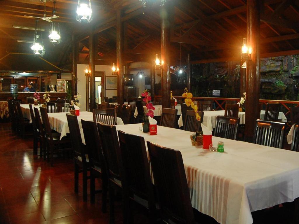 Un comedor con mesas y sillas con mantel blanco. en Hotel Batik Yogyakarta, en Yogyakarta