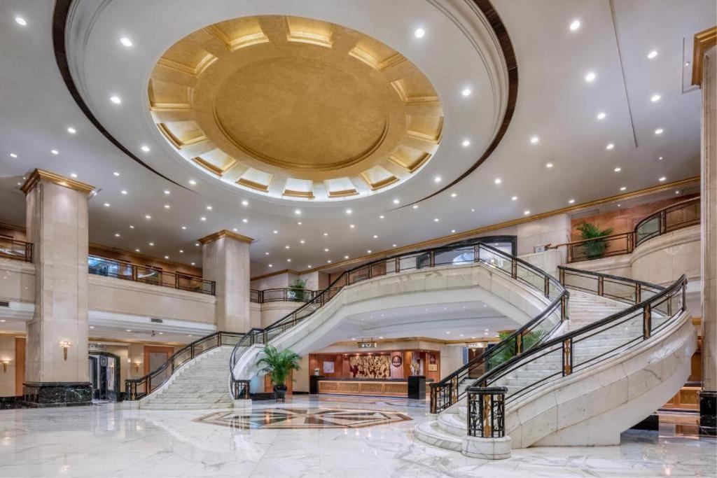 eine große Lobby mit einer Wendeltreppe in einem Gebäude in der Unterkunft Gold Source Sunshine Hotel in Changsha