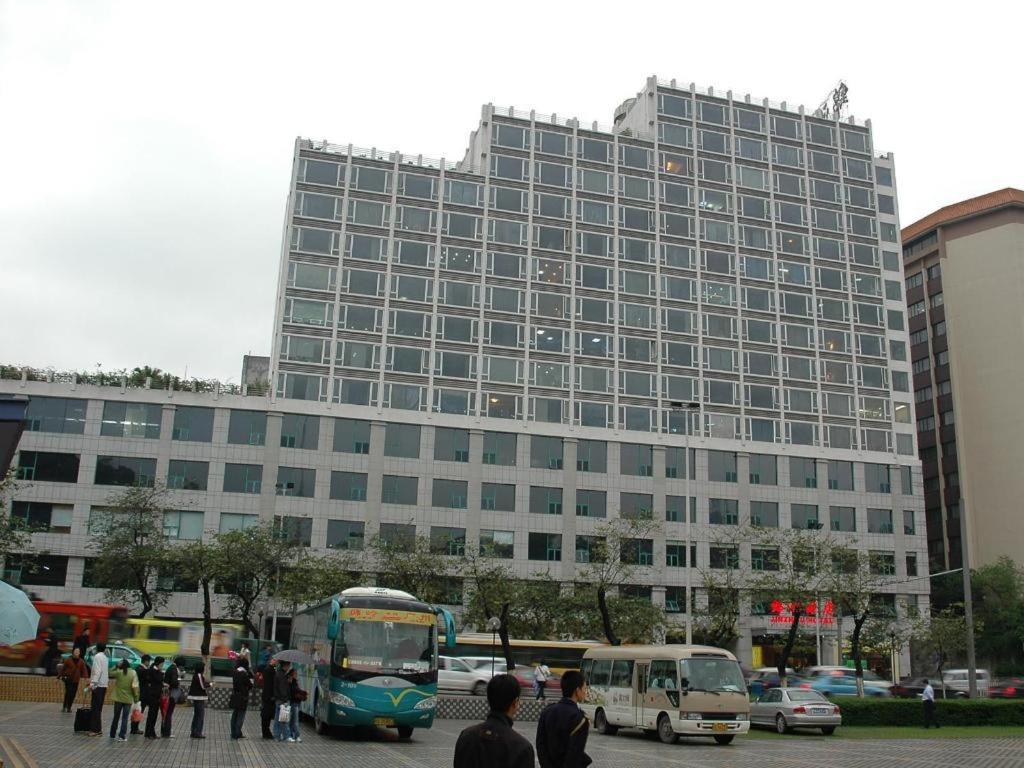 a large building with buses parked in front of it at Jinzhou International Business Hotel in Guangzhou