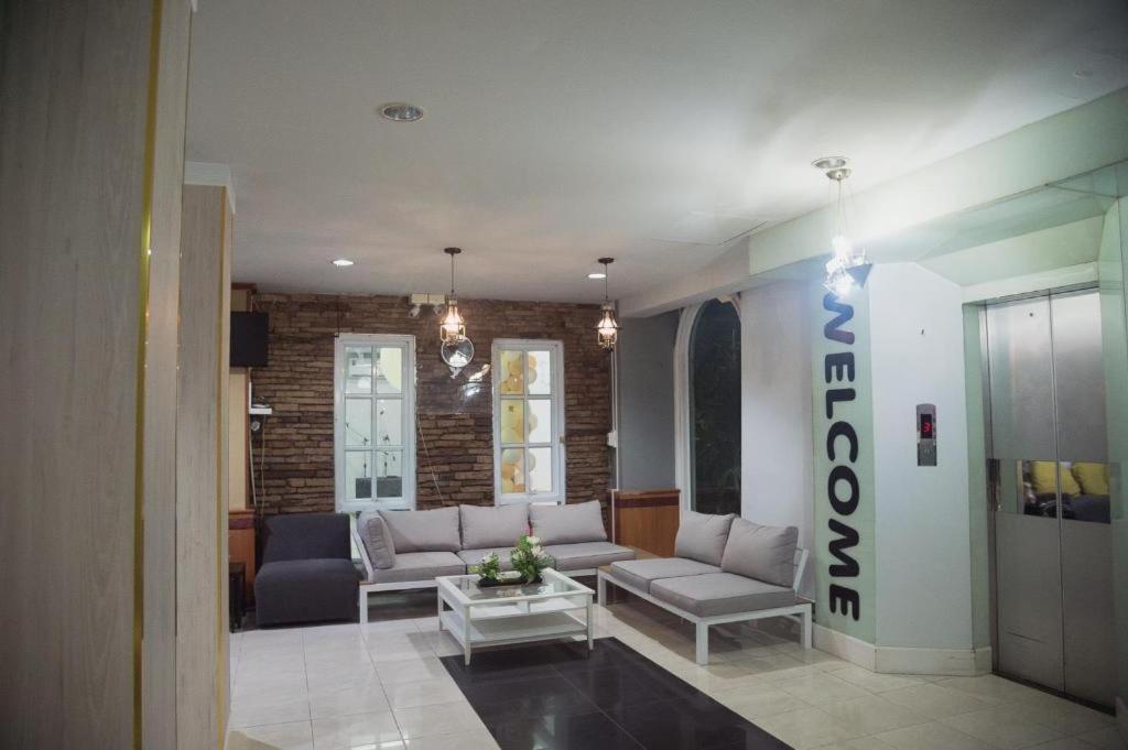 un salon avec un canapé et une table dans l'établissement Atikarn Princess Hotel & Resort, à Udon