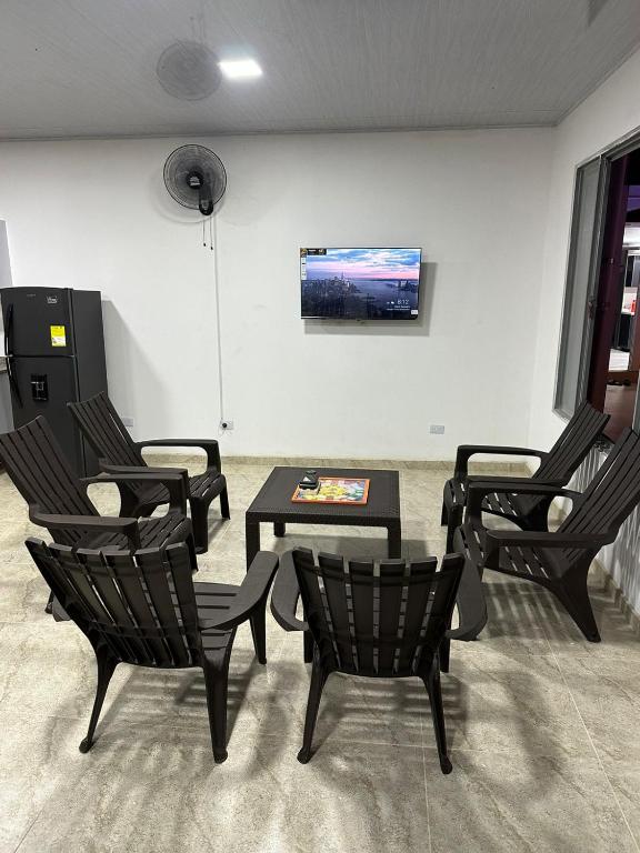 Zimmer mit Stühlen, einem Tisch und einem TV in der Unterkunft Casa Acacías Meta con Piscina y Jacuzzi in Acacías