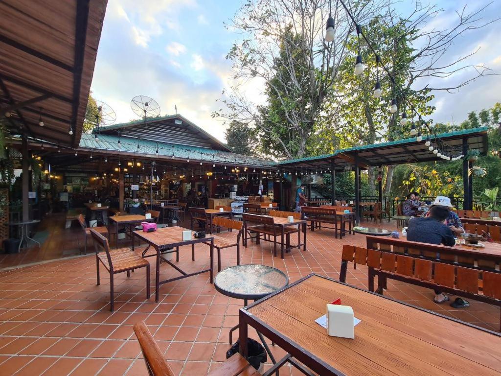 ein Restaurant mit Tischen und Stühlen und Menschen sitzen in der Unterkunft Raisongrao Resort Khao Kho in Ban Huai Phai