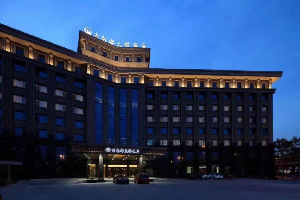 a large building with a building with a sign on it at Nanjing Grand Da Qiao Hotel in Nanjing