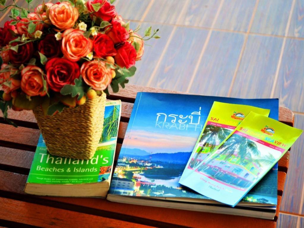 einen Tisch mit zwei Büchern und einer Vase Blumen in der Unterkunft Sairougn Seaview Hotel in Ban Ko Kwang