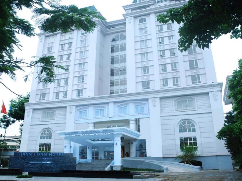 a large white building with a sign in front of it at Draco - Thang Long Hotel in Hai Phong