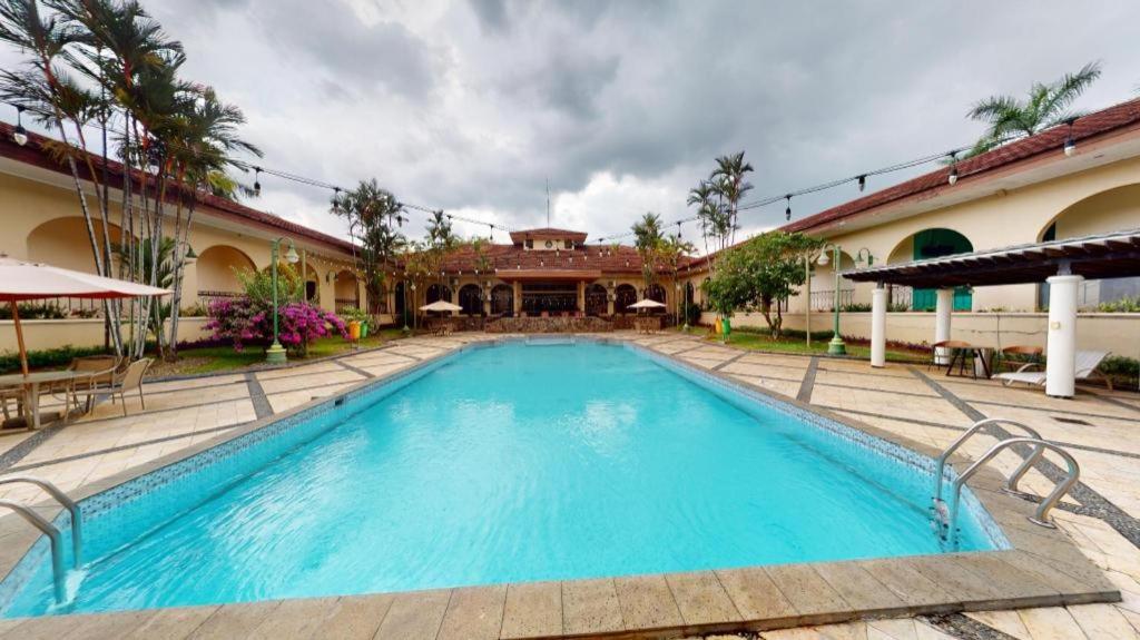 a swimming pool in front of a house at Ole Suite Hotel in Bogor