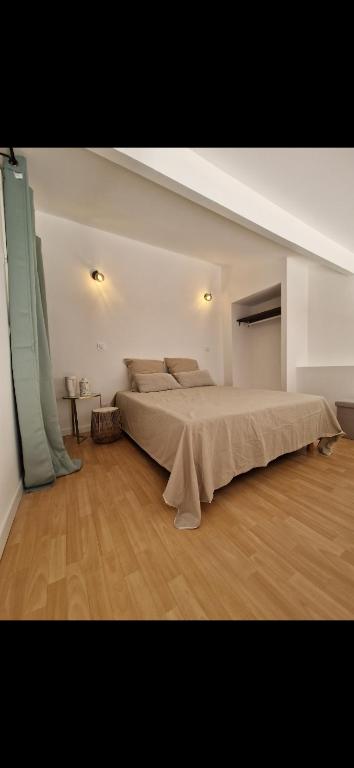 une chambre avec un grand lit dans une pièce dans l'établissement Appartement a 5min de la plage, à Penta-di-Casinca