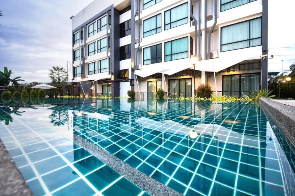 ein Schwimmbad vor einem Gebäude in der Unterkunft UDTel Boutique Hotel Udonthani in Ban Dong Kheng