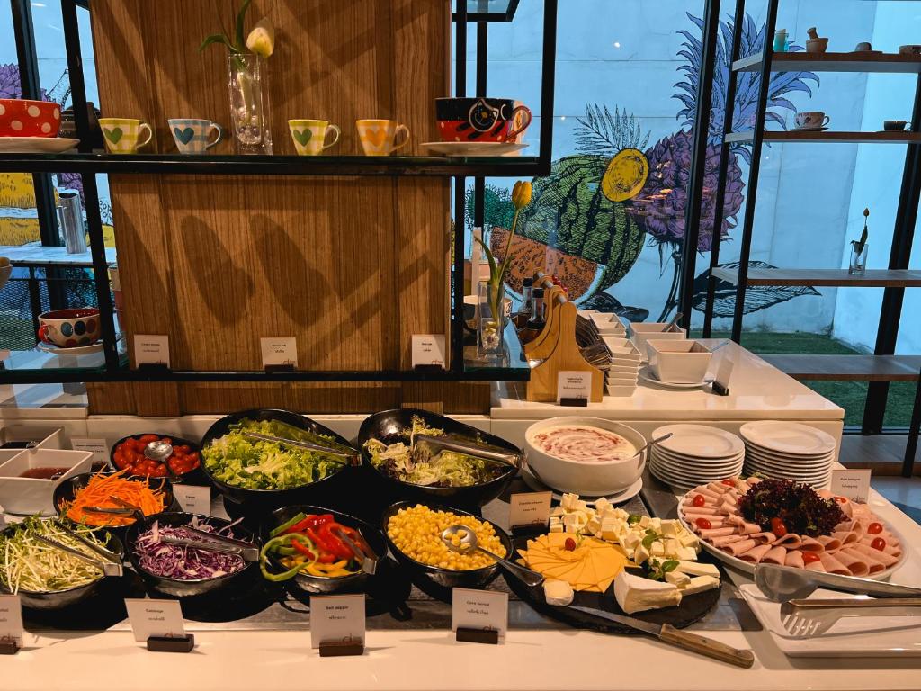 A buffet station offering salads, cold cuts, cheese, and fruit.