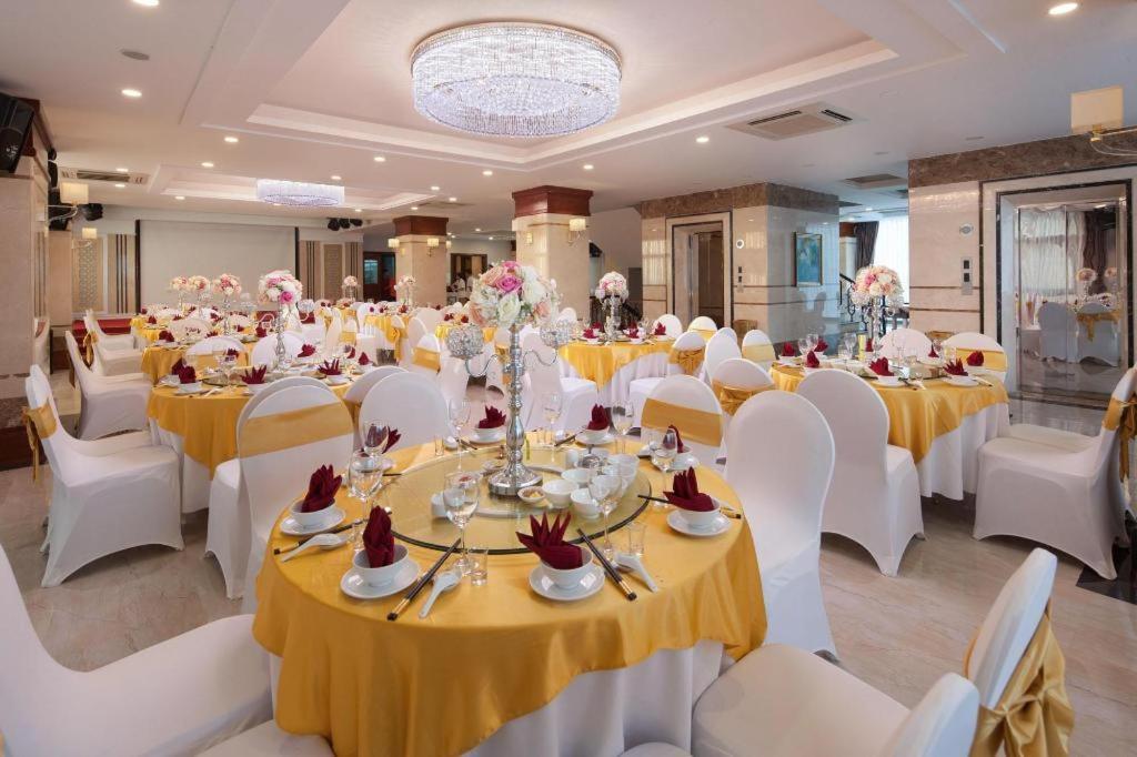 a banquet hall with white tables and white chairs at Royal Palace Hotel in Tuyên Quang