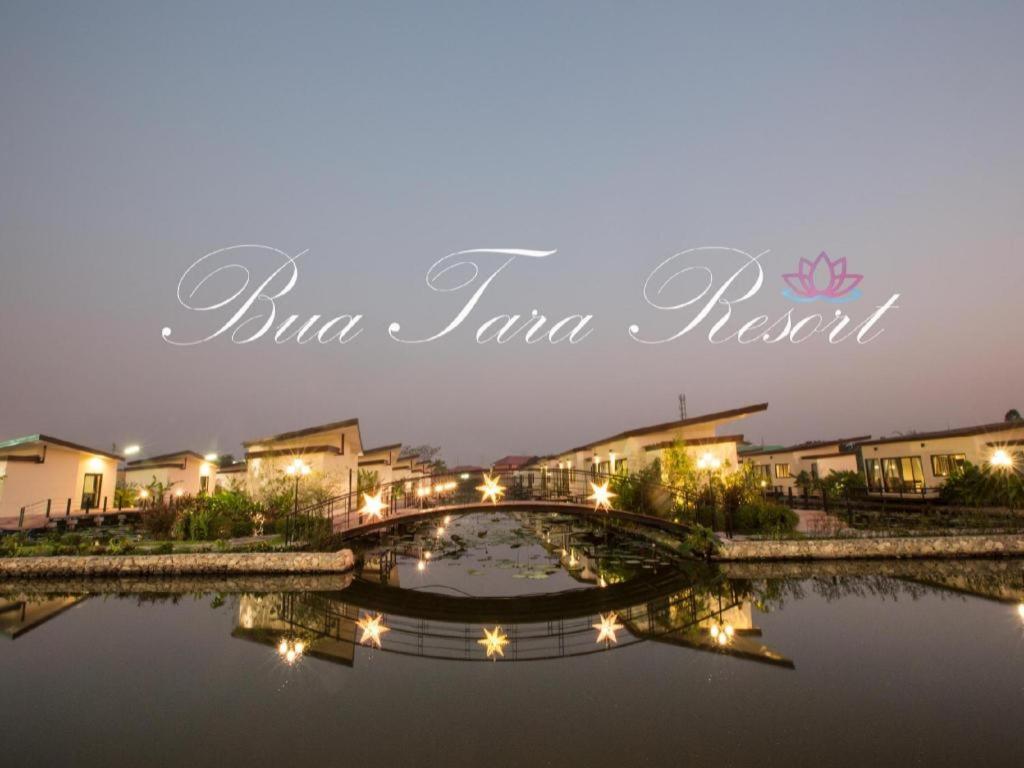 a bridge over a body of water with buildings at Bua Tara Resort in Nong Prue