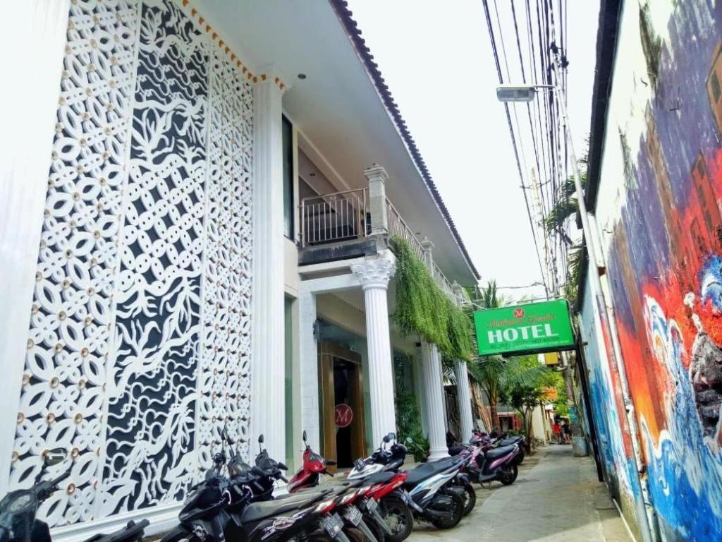 ジョグジャカルタにあるMalioboro Garden Hotel Yogyakartaのホテル外に駐輪する一連のオートバイ