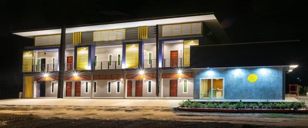 a large building with lights on it at night at Nithra Ratree Hotel in Si Maha Phot