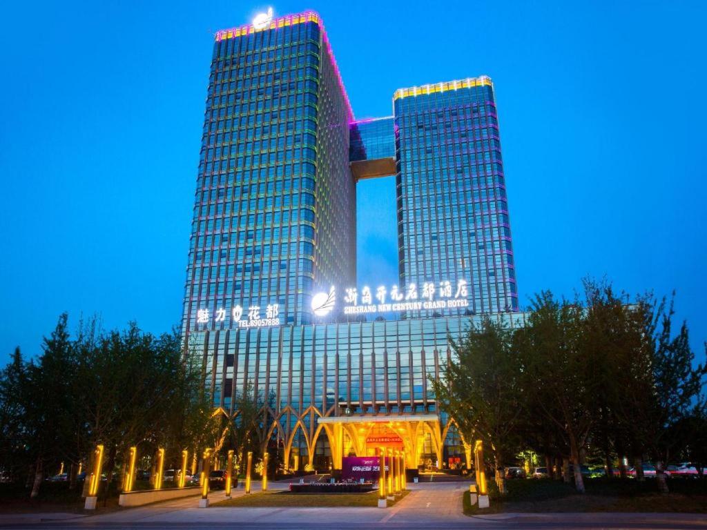 a tall building with lights on it at night at New Century Grand Hotel Hangzhou Zheshang in Yuhang