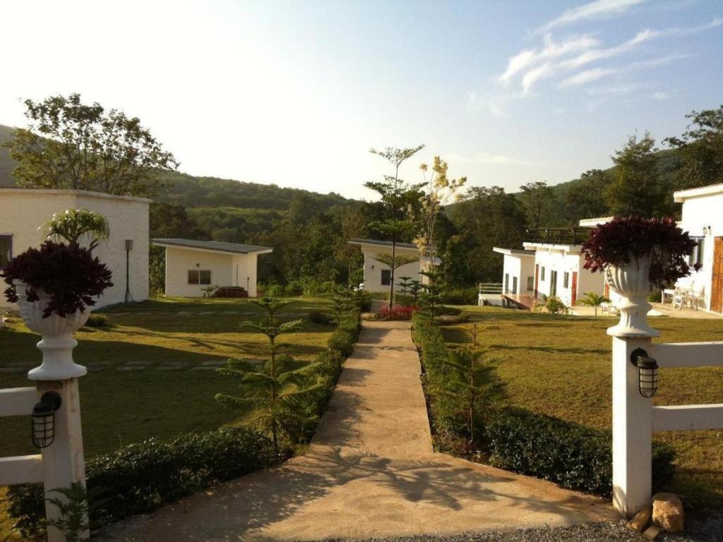 ein Weg mit zwei weißen Vasen auf einem Zaun in der Unterkunft White Rock Resort Pakchong in Ban Nong Ka Cha