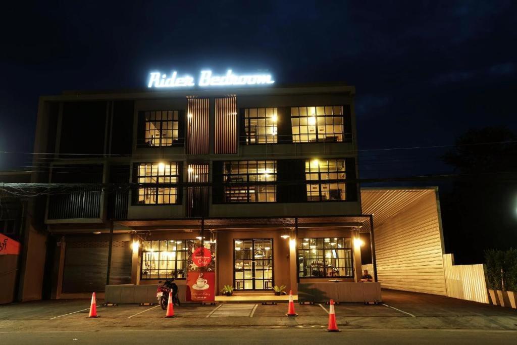 ein Gebäude mit einem Schild darüber in der Nacht in der Unterkunft Rider bedroom hostel & cafe in Pran Buri