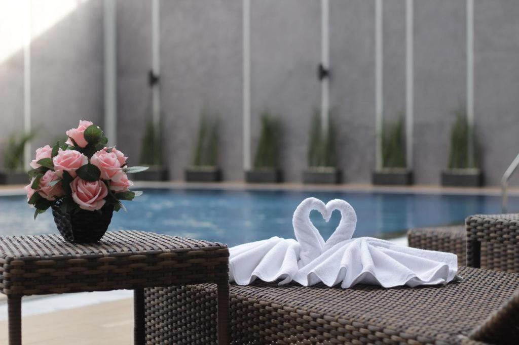 a table with a swan napkin and flowers on it at Atrium Premiere Cilacap in Cilacap