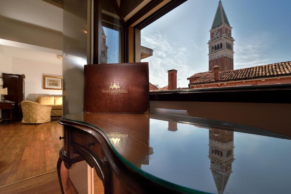 a glass table with a piano in a room with a clock tower at San Marco Palace in Venice