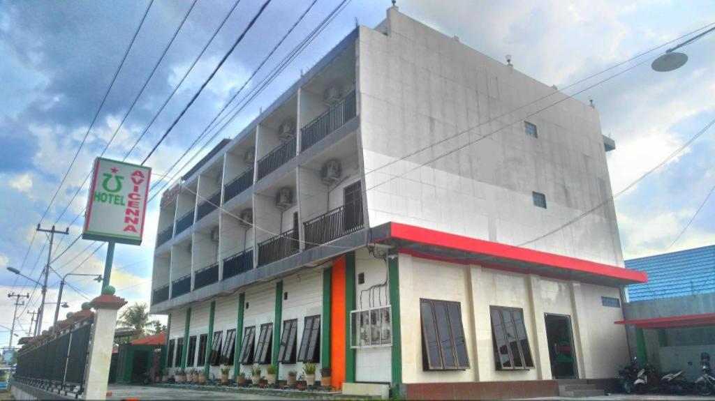 a white building with a sign in front of it at Avicenna Hotel in Palangkaraya