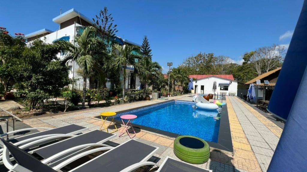 a swimming pool with chairs and a house at Villa Sapphire in Vung Tau