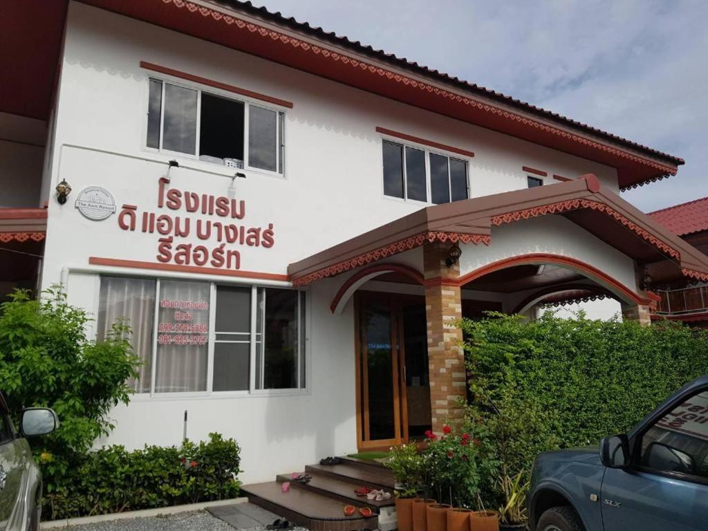 The Aam resort في بانغ ساري: بيت أبيض عليه لافتة مكتوب عليها إيزيسيليا أيلورشيس ساجيستيشن