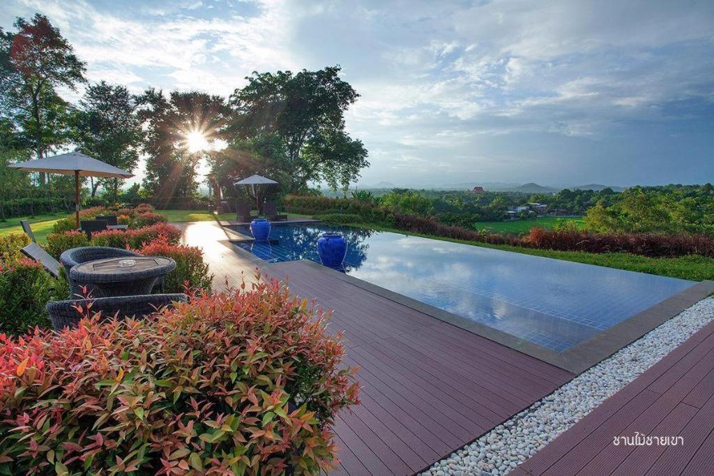einen Pool in einem Garten mit Sonne in der Unterkunft Nan Boutique Resort in Ban Hua Wiang Nua