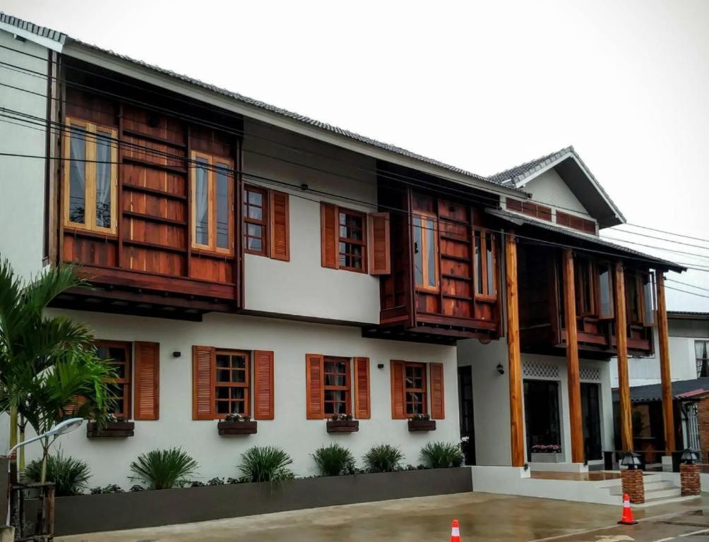 a building with wooden shutters on it at Phumin Place Hotel in Nan