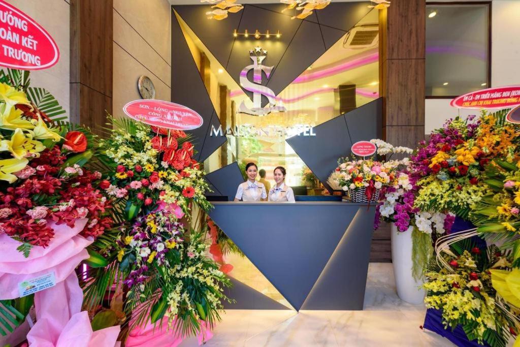 two people standing at the counter of a flower shop at Maison Hotel Phu Quoc in Phú Quốc