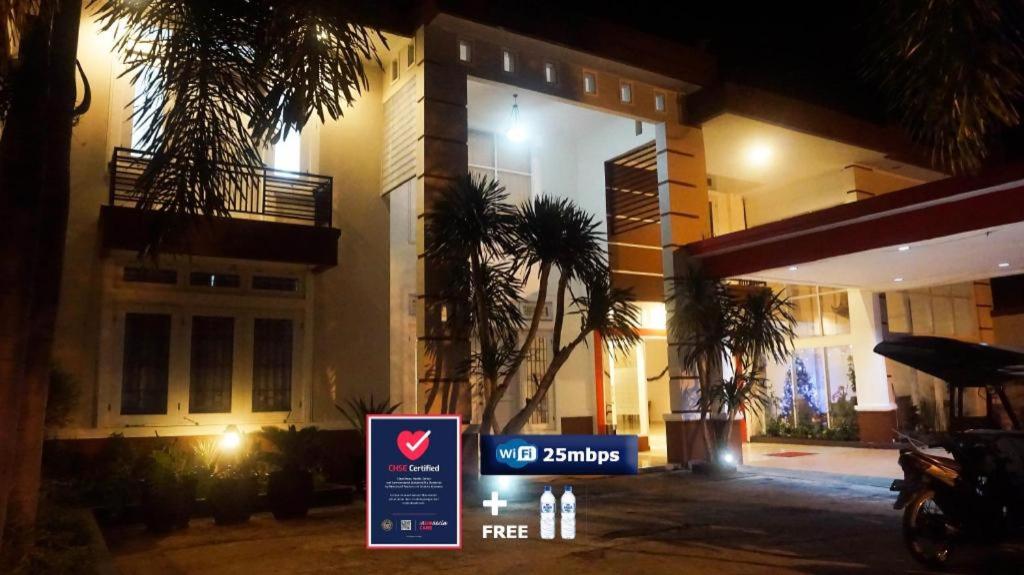 a sign in front of a building at night at The Garden Hotel in Gorontalo